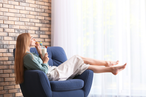 woman with a glass of milkshare in armchair