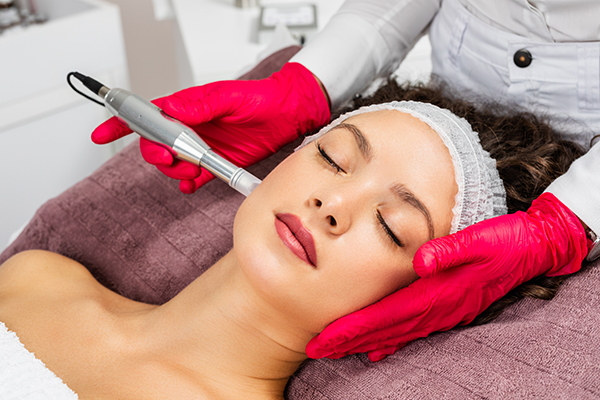 Beautiful woman receiving microneedling rejuvenation treatment