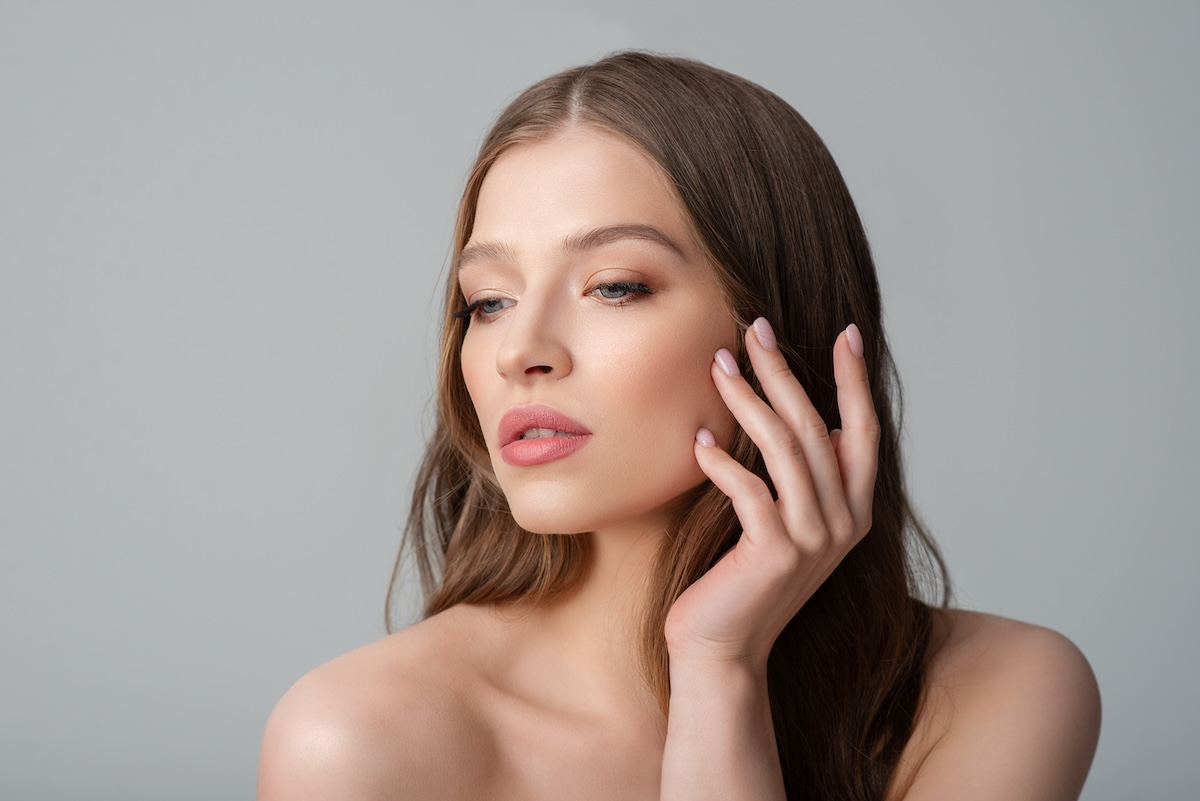 beautiful elegant young woman touching her face