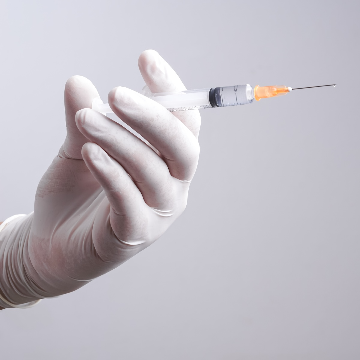 injectable needle in gloved hand