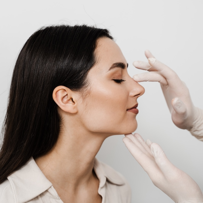 woman with doctor touching her nose